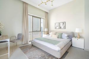 a bedroom with a bed and a desk and a window at GuestReady - Lux living with an infinity pool in Dubai