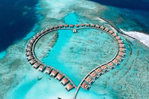Radisson Blu Resort Maldives with 50 percent off on Sea Plane round trip 03 nights & above في Fenfushi: جزيرة على شكل قلب في المحيط