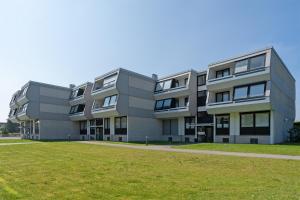 uma fila de edifícios de apartamentos com um campo de relva em Appartementanlage Kammerweg 5-5b Kleinaberfein em Scharbeutz