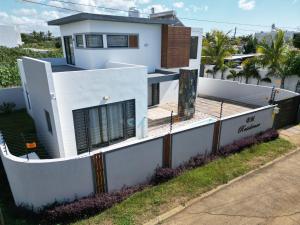 a white house with a fence in front of it at BM Residence in Grand-Baie