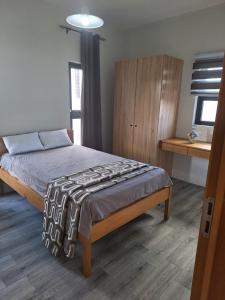a bedroom with a bed and a wooden cabinet at BM Residence in Grand-Baie
