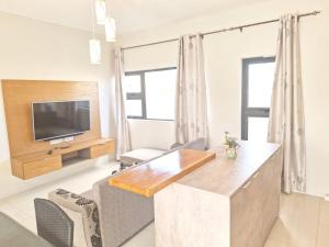 a living room with a table and a tv at BM Residence in Grand-Baie