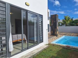 a villa with a swimming pool next to a house at BM Residence in Grand-Baie +21 photos