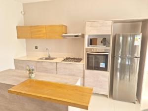 a kitchen with a stainless steel refrigerator and a table at BM Residence in Grand-Baie
