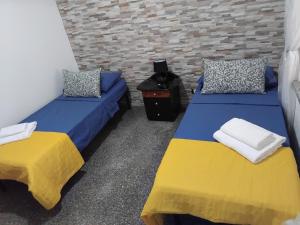 a room with two beds and a brick wall at Contemax in Cetraro