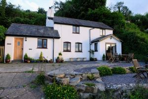 a white cottage with a patio in front of it at Alwyn Cottage in Llangollen