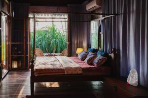 a bedroom with a canopy bed with a window at Villa Fiesta - Beachfront Getaway in Verna