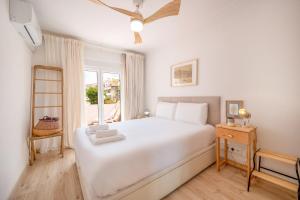 een witte slaapkamer met een wit bed en een raam bij GuestReady - Relaxing stay in Cacilhas in Almada