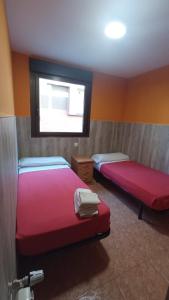 2 Betten in einem Zimmer mit Fenster in der Unterkunft Hostal San Marcos II in Guadalajara