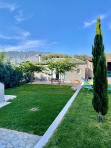 um jardim com relvado e uma casa em Pool Guesthouse em Corinto