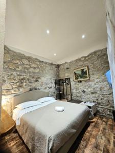 a bedroom with a bed and a stone wall at PRESTIGE casa vacanze in Catanzaro