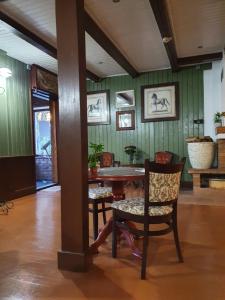 einen Tisch und Stühle in einem Zimmer mit grünen Wänden in der Unterkunft Pušelė in Šiauliai