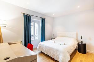 1 dormitorio con 1 cama blanca y 1 silla roja en GuestReady - Your Pied-à-Terre near Princes Park en París