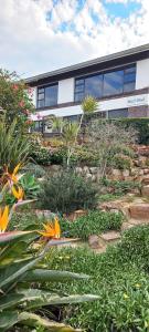 a building with a garden with flowers in front of it at Beach Break B&B - Solar Powered in Port Alfred
