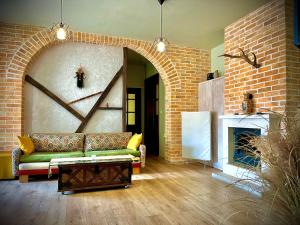 a living room with a couch and a brick wall at The Sunny Guest House of Veliko Turnovo in Veliko Tŭrnovo
