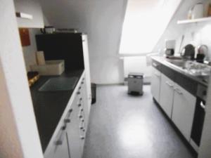 a kitchen with white cabinets and a black refrigerator at Ferienwohnung am Bodensee in Uhldingen-Mühlhofen