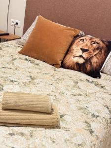 a lion head pillow on top of a bed at Katrina - Kunigiškių apartamentai - Mano Jūra 2 in Palanga