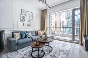 a living room with a blue couch and a large window at GuestReady - Comfort Stay l Close To Marina Mall in Dubai