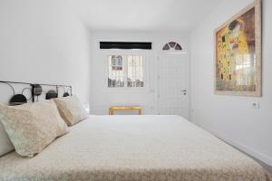 a white bedroom with a large white bed with pillows at Casa Alsa Beach in Icod de los Vinos