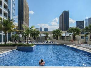 a woman in a swimming pool in a city at GuestReady - Comfort Stay l Close To Marina Mall in Dubai