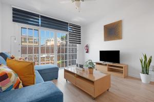 sala de estar con sofá azul y TV en Casa Alsa Beach en Icod de los Vinos