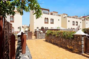 a house with a stone wall and a fence at Casa Alsa Beach in Icod de los Vinos