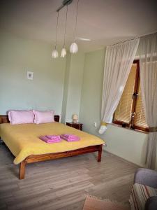 Un dormitorio con una cama con almohadas rosas. en The Sunny Guest House of Veliko Turnovo, en Veliko Tŭrnovo