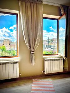 a room with two windows and a view of a city at The Sunny Guest House of Veliko Turnovo in Veliko Tŭrnovo