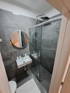 a bathroom with a shower and a sink and a mirror at Paulina Harmony Rooms in Seget Vranjica