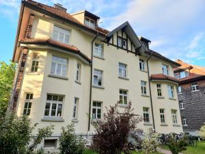 un gran edificio blanco con techo rojo en Aparte 3-Zi-Wohnung im Oberallgäu direkt am Berg!, en Immenstadt im Allgäu