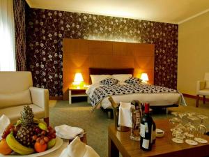 ein Hotelzimmer mit einem Bett und einem Tisch mit einem Obstteller in der Unterkunft Grand Nur Plaza Hotel in Aqtau