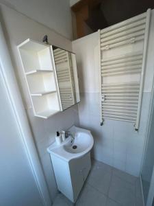 a white bathroom with a sink and a mirror at Scalo 71 GUEST HOUSE in Rome