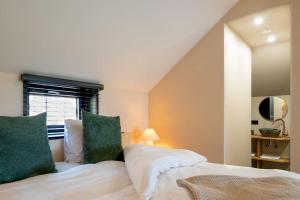 a bedroom with a white bed with green pillows at Bed en Wijn - Suite Landhuisje in Staphorst