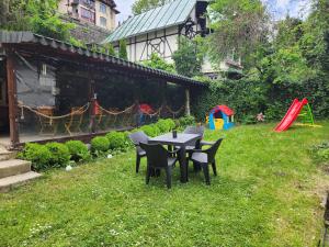 a table and chairs in a yard with a playground at Vila Agata in Sinaia