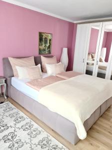 a bedroom with a large bed with purple walls at Ferienwohnung Kespergarten in Witzenhausen