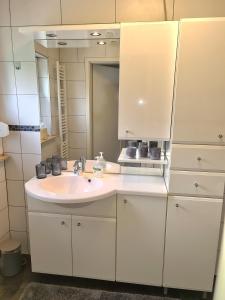 a bathroom with a white sink and a mirror at Ferienwohnung Kespergarten in Witzenhausen