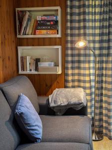 a living room with a couch and a lamp at South Soul Cottage in Somme-Leuze