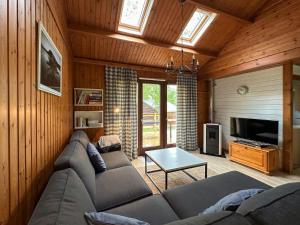 un soggiorno con divano, tavolo e TV di South Soul Cottage a Somme-Leuze