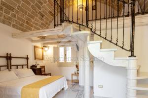 a bedroom with a white bed and a staircase at SANTA LUCIA DIMORA in Taviano