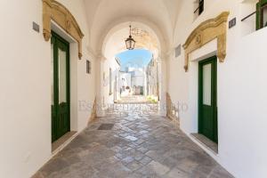 a corridor of an alley with green doors at SANTA LUCIA DIMORA in Taviano +49 photos