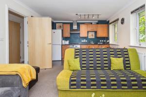 sala de estar con sofá amarillo y cocina en Global Boutique Relocation Ltd 2Bed -free parking en Hatfield