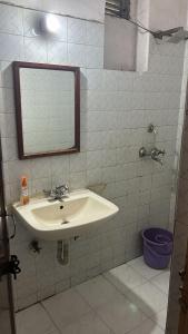 y baño con lavabo y espejo. en Hotel Krishna Palace, en Nueva Delhi