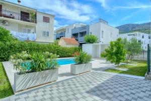 a courtyard with a swimming pool and some buildings at Cozy New Apartments with Private Pool Podstrana in Podstrana