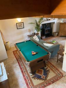 a pool table in the middle of a living room at Maison L’allee in Lézignac-Durand