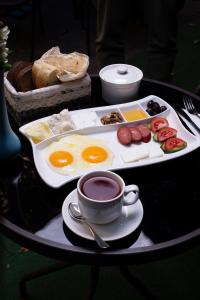 ein Tablett mit Eiern und eine Tasse Kaffee auf dem Tisch in der Unterkunft Grand Nur Plaza Hotel in Aqtau