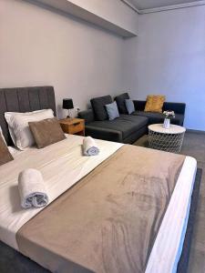 un grande letto in un soggiorno con divano di Jolie Studios & Apartments a Eforie Nord