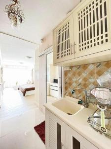 a kitchen with a sink and a living room at Ninman Top1 in Chiang Mai