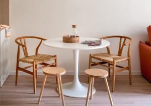 Apartahotel Líbere Vitoria في فيتوريا جاستيز: طاولة بيضاء مع كرسيين وطاولة بيضاء مع طاولة