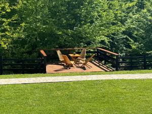 un patio con 2 sillas y una mesa en el césped en Kuca za odmor Marjanovic en Gornji Milanovac