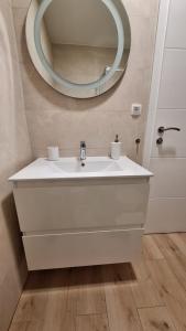 een badkamer met een witte wastafel en een spiegel bij Ceratonia Apartments in Lovište